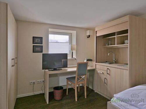 Blick zu Kleiderschrank und TV - 1 Zimmer Etagenwohnung zur Miete in Kassel