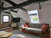 TV und Couch im großen Schlafzimmer - 