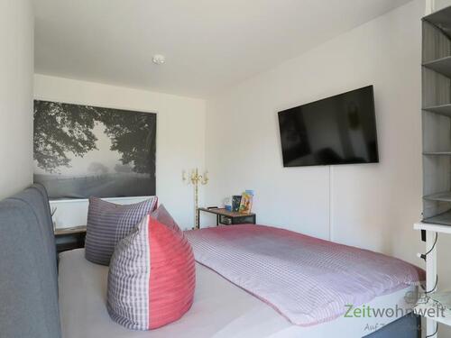 Bett und TV hinter dem Raumteiler - 