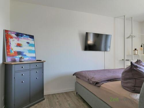 Kommode und Bett hinter dem Raumteiler - 1 Zimmer Etagenwohnung in Irxleben