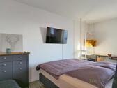 Doppelbett und TV hinter dem Raumteiler - Etagenwohnung mit 55,00 m² in Irxleben zur Miete