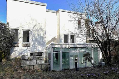 Architektonische Rückansicht mit Wintergarten und gewachsenem Garten - 