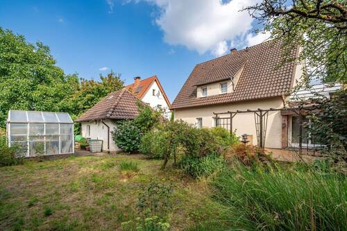 Im Garten steht ein Gewächshaus. - 