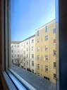 Blick aus dem Wohnzimmerfenster in den grünen Innenhof - 