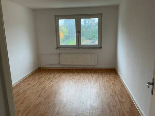 Schlafzimmer mit Bodenbelag in Holzoptik, Wände weiß tapeziert - 