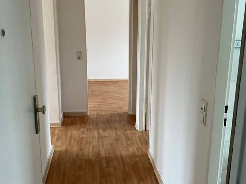 Flur mit Bodenbelag in Holzoptik, Wände weiß tapeziert - 