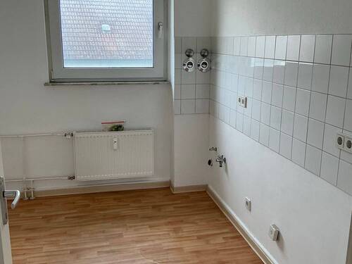 Küche mit Bodenbelag in Holzoptik, Wände weiß tapeziert, Fliesenspiegel in weiß - 