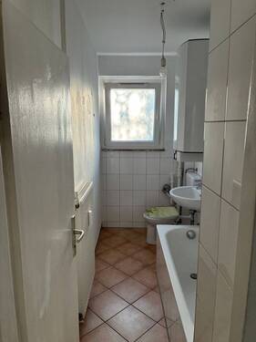 Musterbad: Fenster, Badewanne, weiße Sanitärobjekte, weiße Wandfliesen, braune Bodenfliesen - Etagenwohnung mit 45,80 m&sup2; in Darmstadt zur Miete