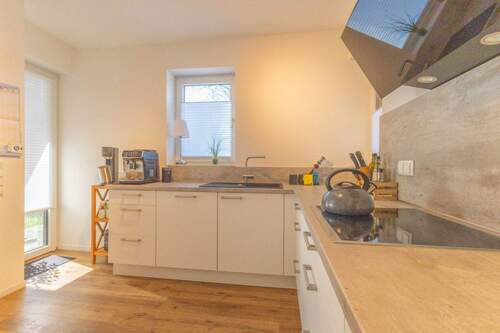 Küche mit Schiebetür zum Wohnzimmer und Zugang zur Terrasse
- 