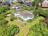 Luftbild Südwestansicht - Großzügiger Winkelbungalow auf traumhaft eingewachsenem 1.626 m² großem Grundstück in begehrter Lage