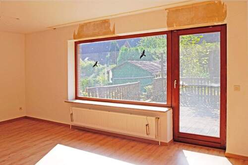 Wohnzimmer mit Tür zur Terrasse - 