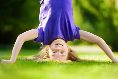 Kind Kopfstand auf Wiese im Garten_shutterstock_70 - 