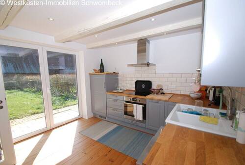 Moderne Küche mit Kochinsel, Edelstahlabzug und direktem Gartenblick - 