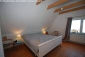 Gemütliches Dachschlafzimmer mit Holzbalkendecke und Dachfenstern - 