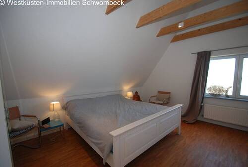 Gemütliches Dachschlafzimmer mit Holzbalkendecke und Dachfenstern - 