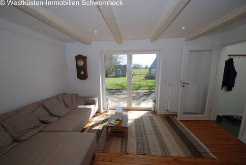 Lichtdurchflutetes Wohnzimmer mit Terrassenzugang und Deckenbalken - 