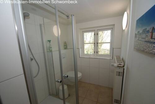 Helles Badezimmer mit bodengleicher Dusche und Fensterbelichtung - 