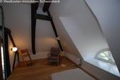 Dachgeschoss-Zimmer mit Spitzbogenfenster und Balkenwerk - 