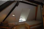 Dachgeschoss-Schlafzimmer mit Spitzbogenfenster und Balkenwerk - 