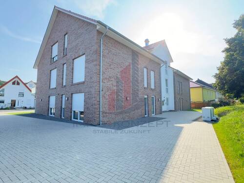 Eine Seitenansicht des neu gebauten Mehrfamilienhauses - 