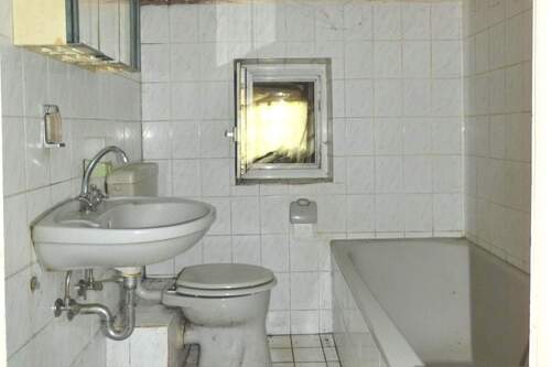 Das Badezimmer mit Wanne und Fenster - 