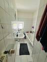 Badezimmer mit Badewanne und Fenster - 