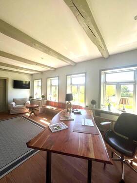 Der traditionelle nordfriesische Stil mit Elementen wie einem Kamin, natürlichen Materialien und einer klassischen Möblierung schafft eine Atmosphäre, die Ruhe und Behaglichkeit ausstrahlt - 