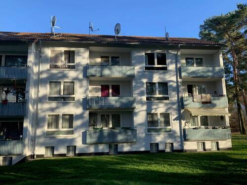 Mehrfamilienhaus mit Bäumen im Vordergrund und Balkonen zu jeder Wohnung - Etagenwohnung mit 51,10 m&sup2; in Stadtallendorf zur Miete