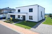 Vorderansicht mit Doppelgarage - Neuwertiges Ein- bis Zwei-Familienhaus in sonniger Feldrandlage mit traumhaftem Ausblick