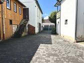 gepflasterter Hof mit Nebengebäuden - 