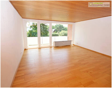 Wohnzimmer und Blick zum großen, sonnigen Balkon - 