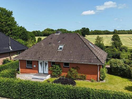 Die Straßenansicht mit Feldrandlage - Freundliches und kompaktes Einfamilienhaus am Feldrand in Hohn