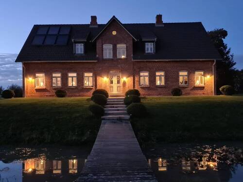 Ansicht des Anwesens in der Dämmerung zeigt die Beleuchtung und vermittelt eine warme, einladende Atmosphäre - 1 Zimmer Einfamilienhaus zum Kaufen in Neukirchen