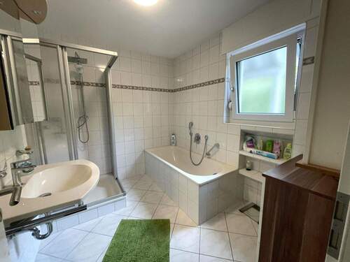 weiteres Tageslichtbad im Erdgeschoss mit Waschbecken, Dusche und Badewanne - 