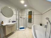 Badezimmer im Dachgeschoss mit Waschbecken, Dusche und Badewanne - 