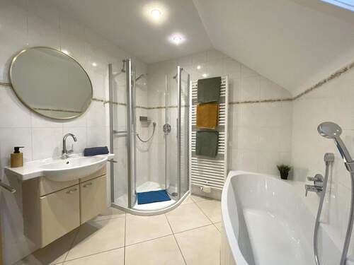 Badezimmer im Dachgeschoss mit Waschbecken, Dusche und Badewanne - 