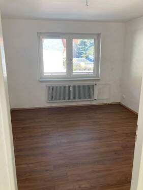 Schlafzimmer mit weiß angelegten Wänden und braunem Vinyl-Designboden in Holzoptik - 