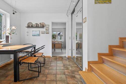 Wohnraum mit offenem Treppenaufgang, gesehen vom Eingang - 