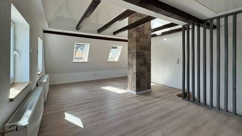 Raum mit offener Decke und Sichtbalken - 