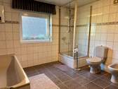 Badezimmer mit Tageslicht, Badewanne und Bidet - 