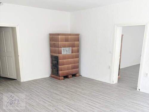 Wohnzimmer mit Kachelofen und Blick Richtung Schlafzimmer - 2 Zimmer Etagenwohnung zur Miete in Mühlberg