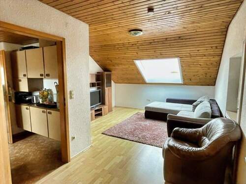 Wohnzimmer mit angrenzender Küche im Dachgeschoss - 