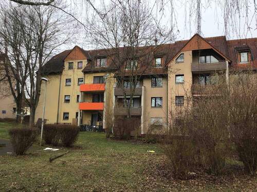 T.-Heuss-Allee 11, Außenansicht mit Blick über den begrünten Innenhof auf die Balkonseite eines mehrgeschossigen Wohngebäudes in Reihenbebauung. - Ideal für Zwei: Kleine 2-Zimmerwohnung in zentraler Lage von Altenbauna