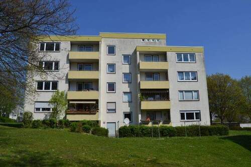 Birkenallee 91, Außenansicht über die Grünanlage mit altem Baumbestand auf die Südbalkone eines Wohngebäudes mit heller Fassade - 3 Zimmer Etagenwohnung zur Miete in Baunatal
