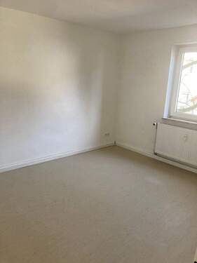 Schlafzimmer mit weiß angelegten Wänden und hellem Linoleumboden - 