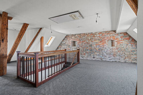 Raumansicht 2 mit historischer Natursteinwand und Holzbalken - 