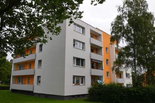 Birkenallee 67, Außenansicht über die Grünanlage mit altem Baumsbestand auf die südlich und östlich ausgerichteten Balkone eine Wohngebäudes mit Flachdach. - 3 Zimmer Etagenwohnung zur Miete in Baunatal