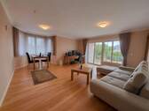 Lichtdurchflutetes Wohnzimmer mit Panorama-Balkonblick - Hochwertige Holzdielen garantieren Wohnkomfort! - 