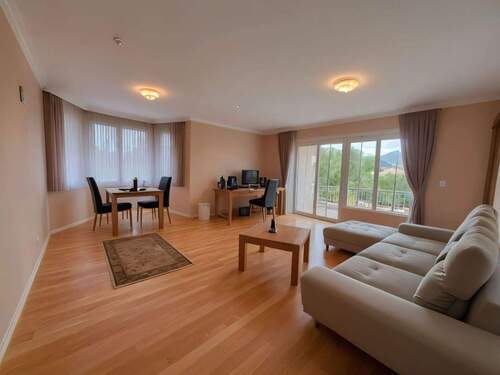 Lichtdurchflutetes Wohnzimmer mit Panorama-Balkonblick - Hochwertige Holzdielen garantieren Wohnkomfort! - 