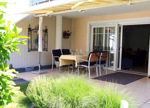 Überdachte Terrasse mit Charme - Einladende Outdoor-Essecke mit Sonnenschutz und elegantem Design - 